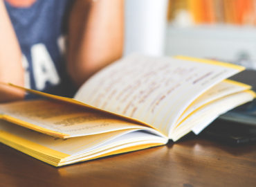 open book on table with person reading