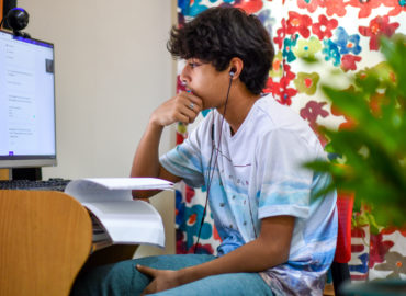 boy with earphones studying at computer
