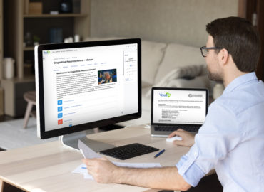 man in front of computer and laptop