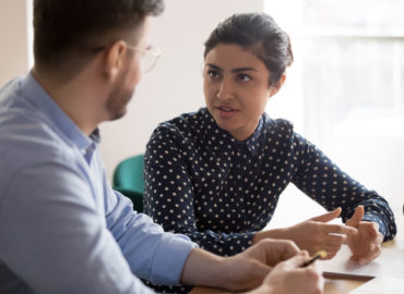 man and woman in discussion at table