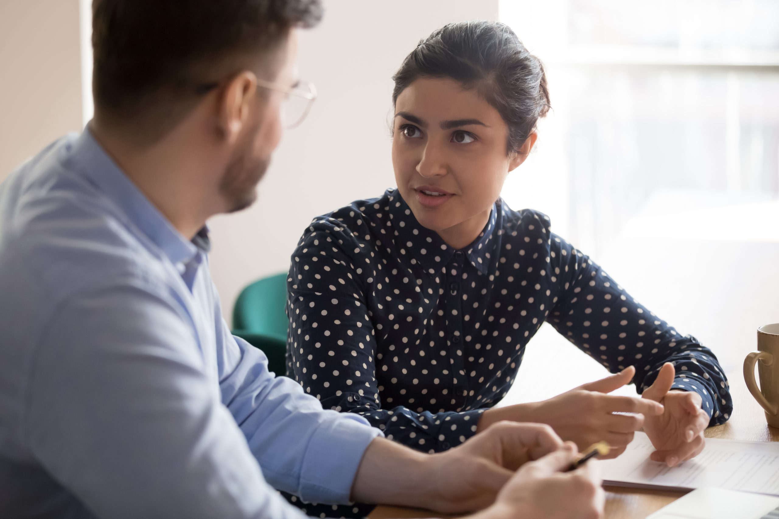 man and woman in discussion at table